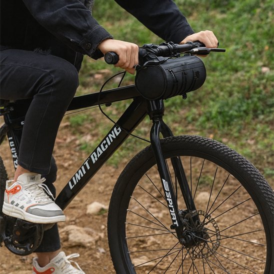 cycliste sur velo dans parc gazon avec sac velo cylindrique noir sur guidon