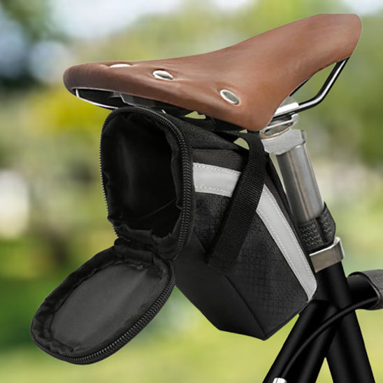 sacoche de selle marron ouverte sur selle velo dans parc