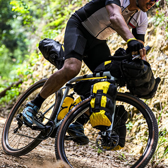 Cycliste en action sur trail avec plusieurs sacoche velo sur cadres et fourches