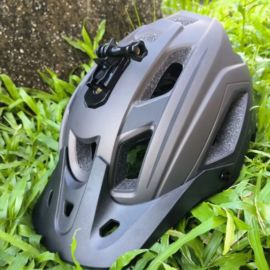 Casque velo route dans l'herbe avec support caméra