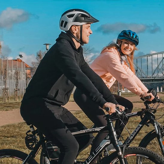 couple cycliste avec casque velo en banlieu