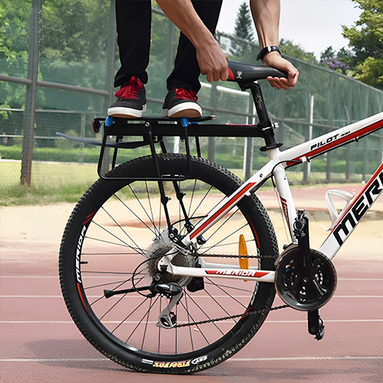 cycliste acrobate debout sur porte bagage velo sur velo qui roule