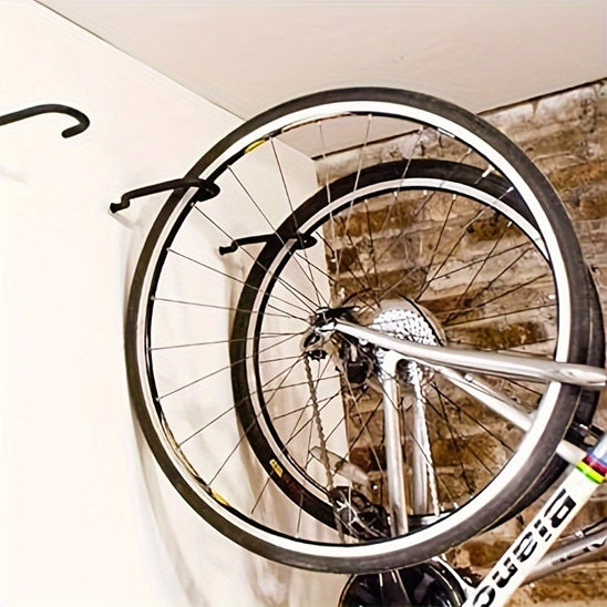 deux velos suspendu au mur a la verticale un retenu par la roue avant et roue arriere avec support velo mural noir