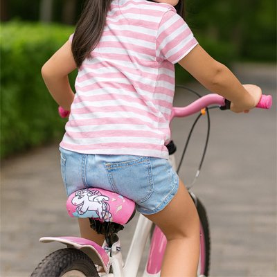 Enfant à vélo avec housse de selle 