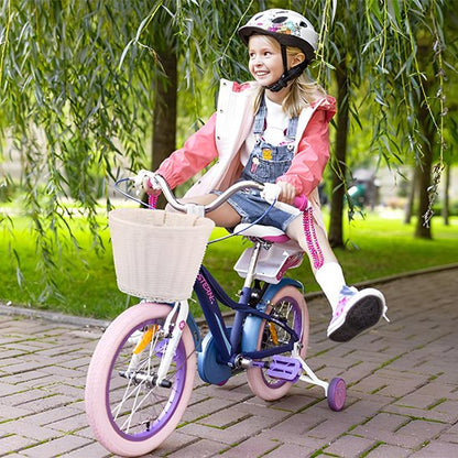 fillette s'amusant sur velo avec petites roues dans parc sous arbre decorer d'un panier a velo blanc tresse simulant osier