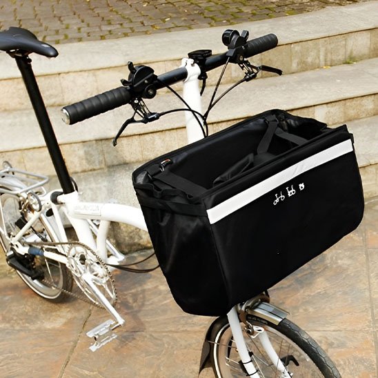 petit velo blanc devant marches sur dalles avec panier velo avant avec sangles pour transporter a la main