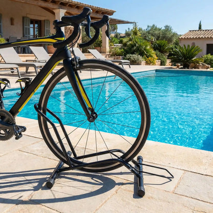 velo-de-route-jaune-et-noir-avec-roue-avant-dans-support-bicyclette-sur-pave-devant-piscine-creuse-dans-villa