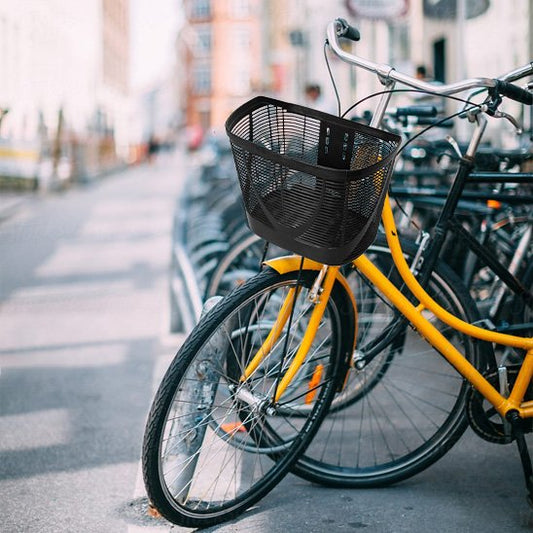 velo urbain jaune avec panier pour velo femme stationne dans support velo de ville pres mutlitudes velos semblabes