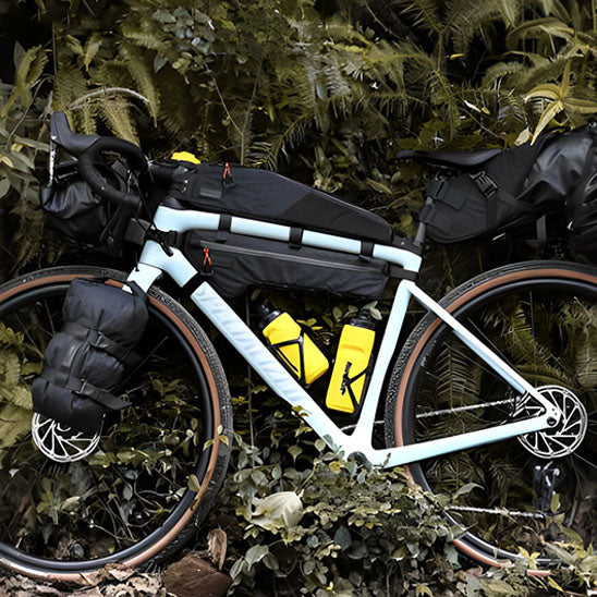 velo avec bagages multiples et sacoche cadre velo devant foret tropicale