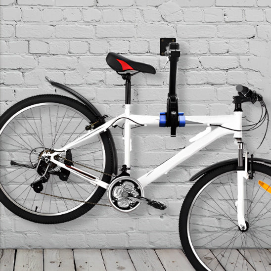 velo_cadre_blanc_eleve_par_support_velo_mural_devant_mur_en_pierres_blanche_et_plancher_bois_blan