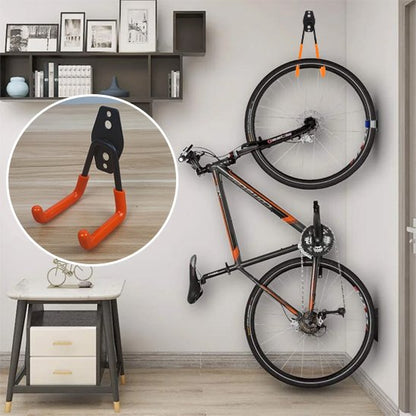 velo noir orange suspendu verticalement au mur par support velo mural dans maison salon