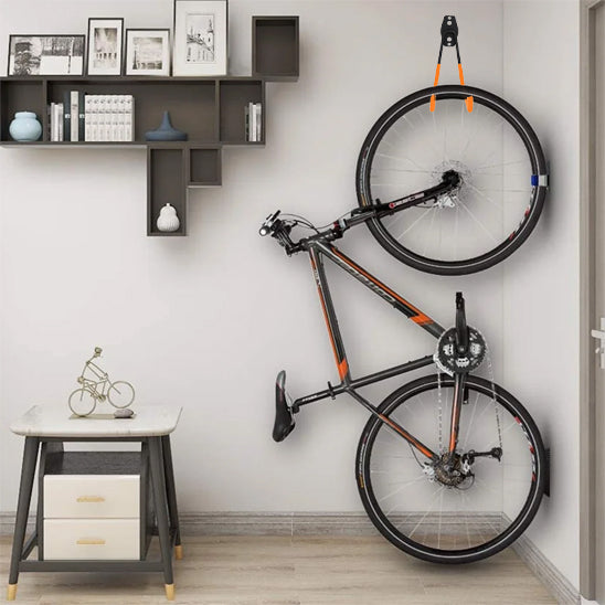 velo_noir_orange_suspendu_verticalement_au_mur_par_support_velo_mural_dans_salon maison