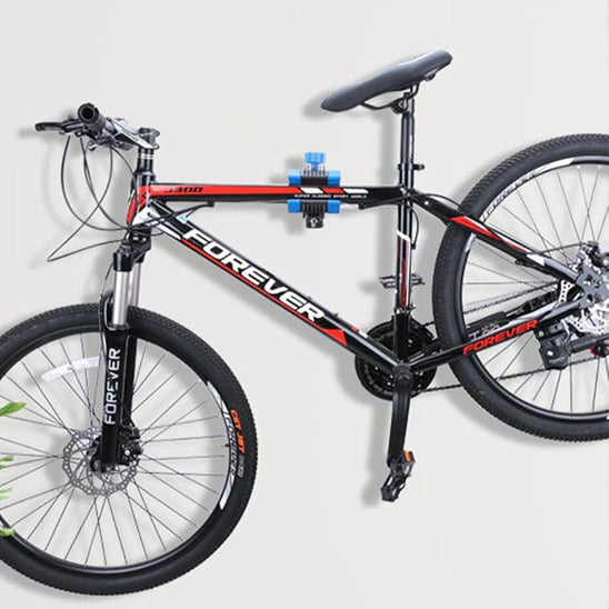 velo_rouge_noir_freins_a_disque_suspendu_sur_mur_blanc_par_support_velo_mur